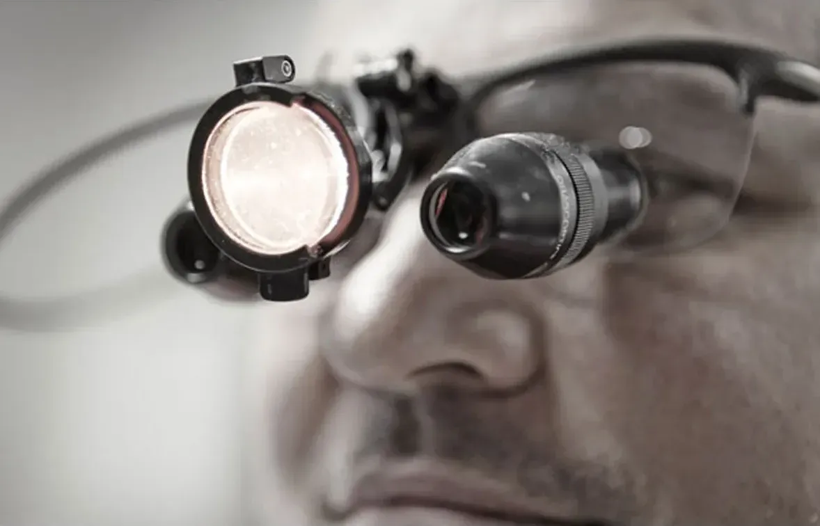 Close view of a dentist wearing magnifying loupes with a headlight